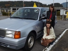 大分・玖珠自動車教習所の合宿教習生が教習車の横で記念撮影した写真景